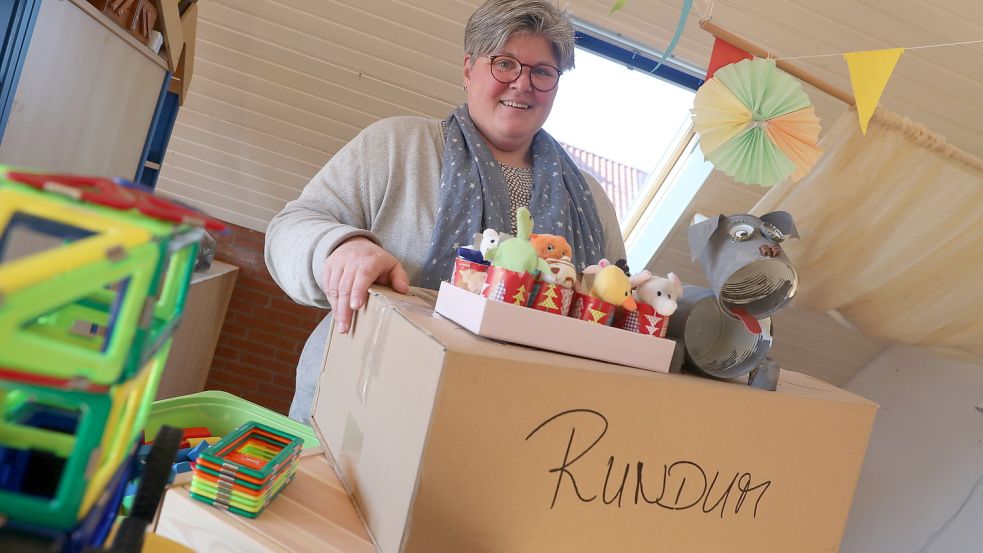 Dagmar Wacker packt schon fleißig Kisten für den Umzug. Von Groß Midlum nach Westerhusen umziehen werden sowohl bunte Geschenke mit Plüschtieren der Kita-Eltern als auch die selbstgebastelten „Haustiere“ der Kinder. Foto: Hock