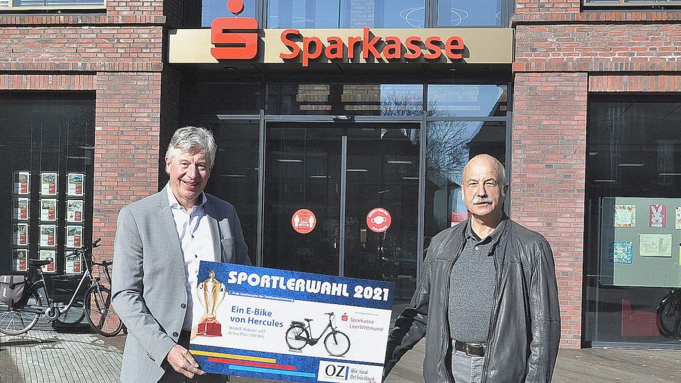 Wolfgang Möller aus Wiesmoor freute sich über den Hauptpreis. Sparkassen-Vorstand Heinz Feldmann überreichte in Leer den Gutschein für ein neues E-Bike. Foto: Wolters