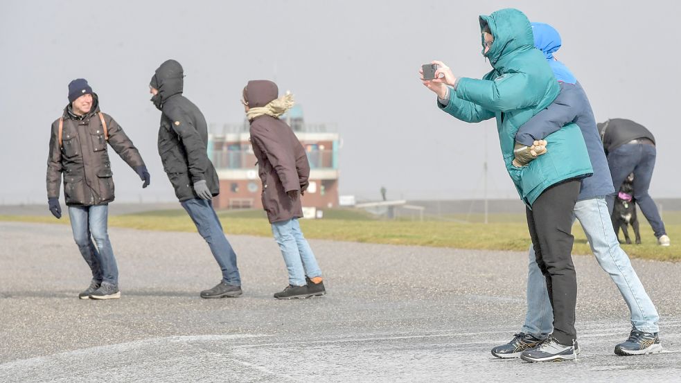 In Norddeich bläst der Sturm so stark, dass sich diese Spaziergänger kaum im Gleichgewicht halten könnten. Foto: Ortgies