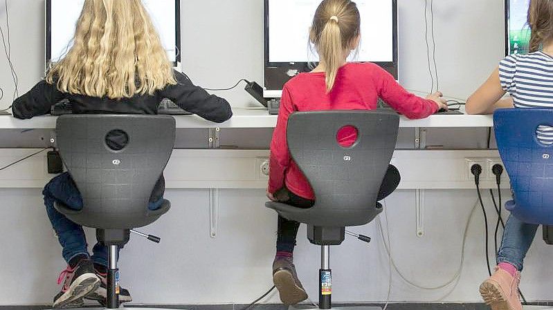 Schülerinnen arbeiten in einem Klassenraum einer Grundschule an Computern. Foto: Friso Gentsch/dpa