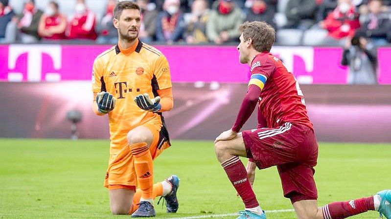 Thomas Müller (r) und Bayern-Torwart Sven Ulreich knien nach dem Eigentor von Müller auf dem Rasen. Foto: Sven Hoppe/dpa