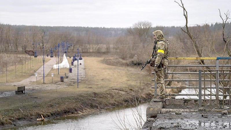 Ein ukrainischer Soldat in der Nähe einer zerstörten Brücke am Fluss Irpin. Foto: Emilio Morenatti/AP/dpa/Symbolbild