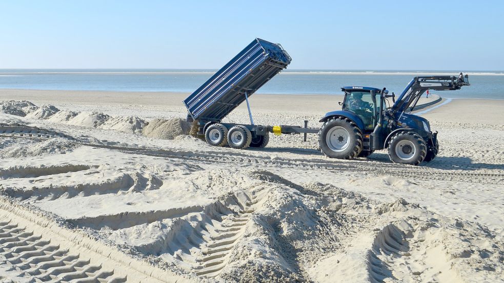 Ein Traktor bringt den Sand zurück, wo er hingehört. Foto: Hoppe
