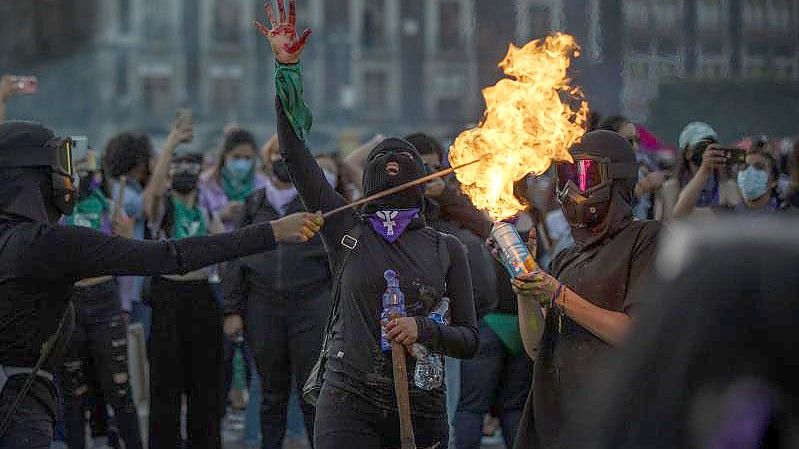 Protest auch in Mexiko-Stadt am Internationalen Frauentag - eine Gruppe vermummter Frauen entzündet Gas aus eine Spraydose. Foto: Jair Cabrera Torres/dpa
