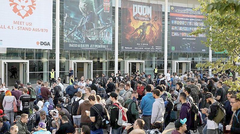 Messebesucher warten im August 2019 vor einer Messehalle der Gamescom auf den Einlass. Foto: Oliver Berg/dpa