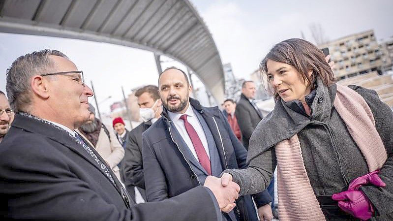 Außenministerin Annalena Baerbock (r.) begrüßt an der Ibar-Brücke Bedri Hamza, (l.) Bürgermeister von Mitrovica-Süd, und Milan Radojevic Bürgermeister von Mitrovica -Nord (M). Foto: Michael Kappeler/dpa