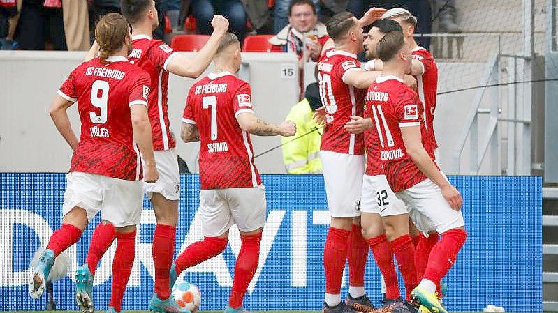 Spieler des SC Freiburg bejubeln das Freistoß-Tor zum 1:0 von Vincenzo Grifo. Foto: Philipp von Ditfurth/dpa