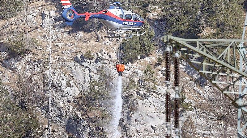 Ein Hubschrauber der österreichischen Polizei über den letzten Brandherden an der deutsch-österreichischen Grenze. Foto: Karl-Josef Hildenbrand/dpa