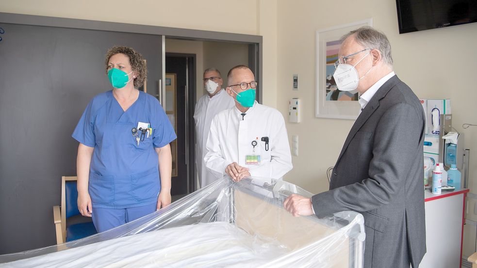 Ministerpräsident Stephan Weil (SPD) im Gespräch mit Mitarbeitern der Intensivstation am Klinikum Leer. Die Klinik-Führung hält gut die Hälfte der Intensivbetten nur als Reserve vor. Foto: Schuldt/dpa