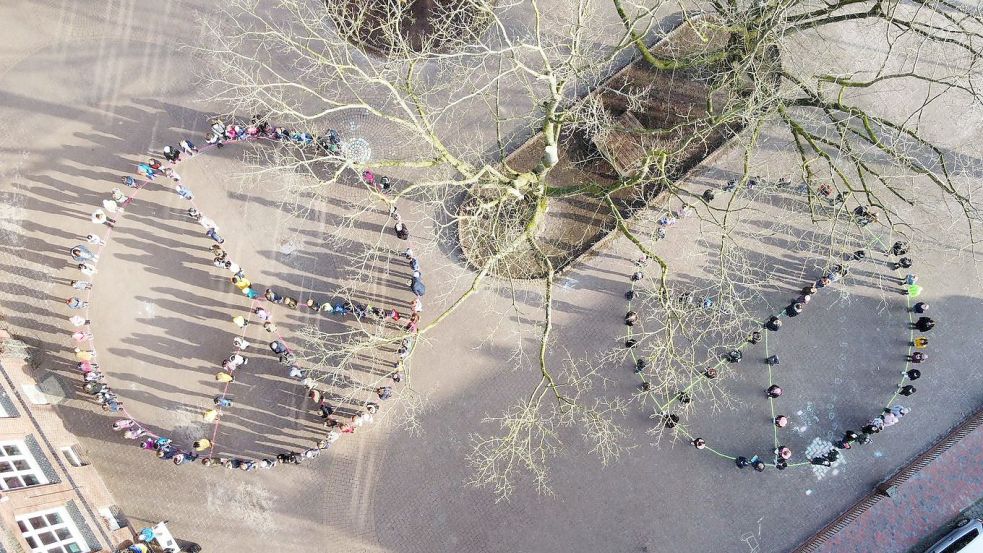 Die Schülerinnen und Schüler sowie das Kollegium der Grundschule am Wall kamen zu einem lebendigen Friedenszeichen auf dem Schulhof zusammen. Foto: Privat