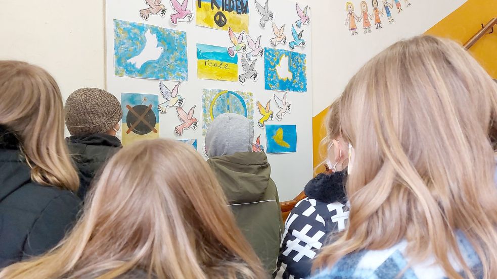 Im Flur der Grundschule am Wall hängen Bilder der 4b, die sie für den Frieden und die Ukraine gemalt haben. Foto: Hanssen