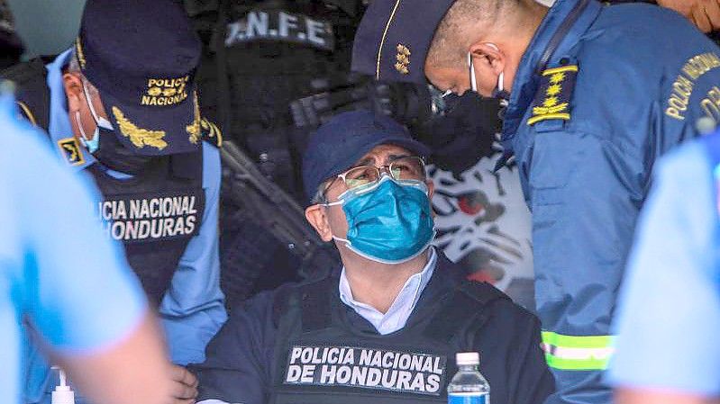 Juan Orlando Hernandez (M), Ex-Präsident von Honduras, spricht mit Polizeibeamten nach seiner Festnahme in seinem Haus. Foto: Indi Ocon/dpa