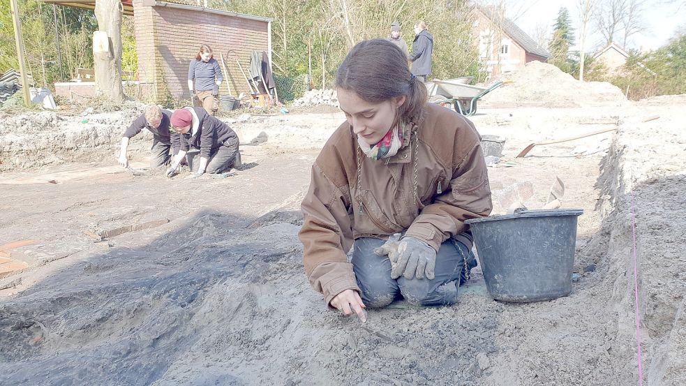 Mit einer schmalen Kelle legt Paula Tavener die Brandschicht im Boden frei. Foto: Gettkowski