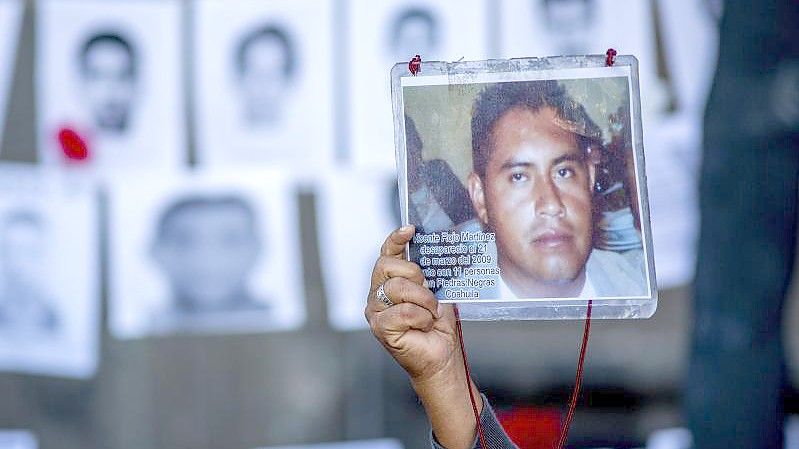 Ein Mann zeigt das Bild seines 2009 verschwundenen Sohnes bei einem Protest in der mexikanischen Hauptstadt.). Foto: Jair Cabrera Torres/dpa