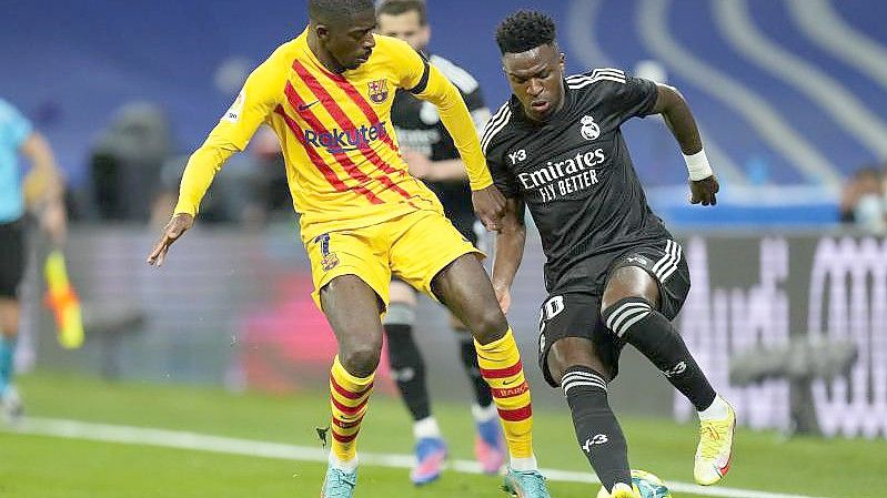 Ousmane Dembélé (l) vom FC Barcelona im Duell mit Real-Profi Vinicius Junior. Foto: Manu Fernandez/AP/dpa