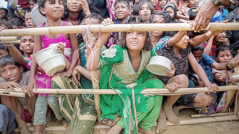 Aus Myanmar vertriebene Kinder der Rohingya warten in einem Flüchtlingslager in Bangladesch auf Nahrungsmittel. Foto: Dar Yasin/AP/dpa
