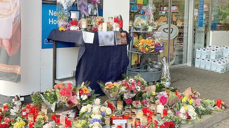 Blumen und Kerzen erinnern an einer Tankstelle in Idar-Oberstein an den jungen Kassierer, der am 18. September 2021 von einem mit einer Pistole bewaffneten Mann erschossen wurde. Foto: Birgit Reichert/dpa