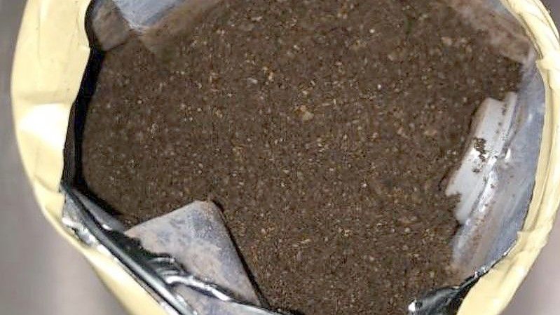 Eine der Kaffeepulververpackungen mit schwarz gefärbtem Kokain wurde vom Zoll geöffnet. Foto: Hauptzollamt Köln/dpa