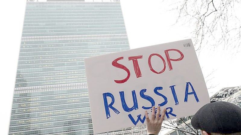 Ein Demonstrant protestiert vor dem New Yorker UN-Hauptquartier gegen den Ukraine-Krieg. Foto: Jeenah Moon/AP/dpa