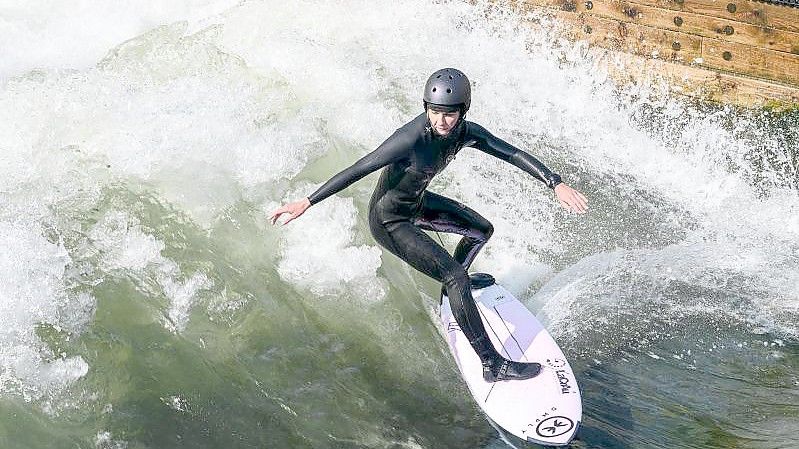 Valeska Schneider surft auf der stehenden Flusswelle. Foto: Daniel Vogl/dpa