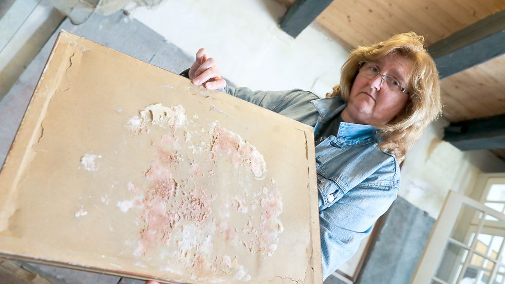 Susanne Rongelraths zeigt an einem Bild, wie stark sich der Schimmel in der Pewsumer Mühle schon ausgebreitet hat. Foto: Hock