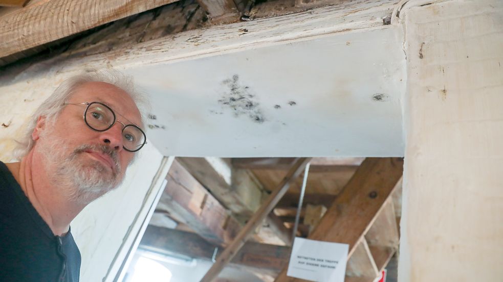 Detlef Meyer-Rongelraths vom Heimatverein Krummhörn vor einem Durchgang, in dem sich schwarzer Schimmel breitgemacht hat. Foto: Hock