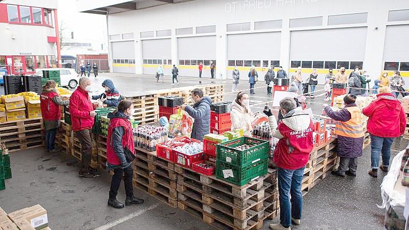 Geflüchtete aus der Ukraine bekommen an einer Ausgabestelle der Hamburger Tafel Lebensmittel und Artikel des täglichen Bedarfs. Foto: Daniel Reinhardt/dpa