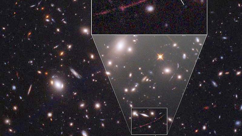 Der Stern mit dem Namen „Earendel“ liegt hinter einem Galaxienhaufen, der als Gravitationslinse dient. Foto: Space Telescope Science Institut/ESA/Hubble/dpa