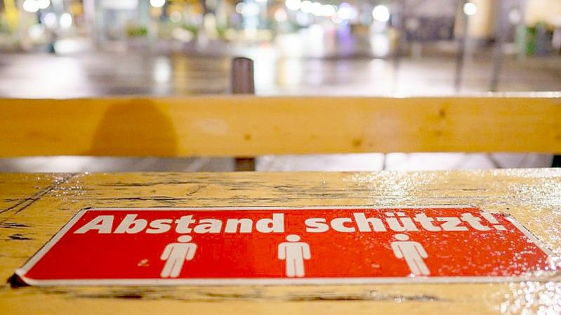 „Abstand schützt“ steht auf Tischen im Außenbereich eines Lokals auf dem Frankfurter Römerberg. Foto: Frank Rumpenhorst/dpa