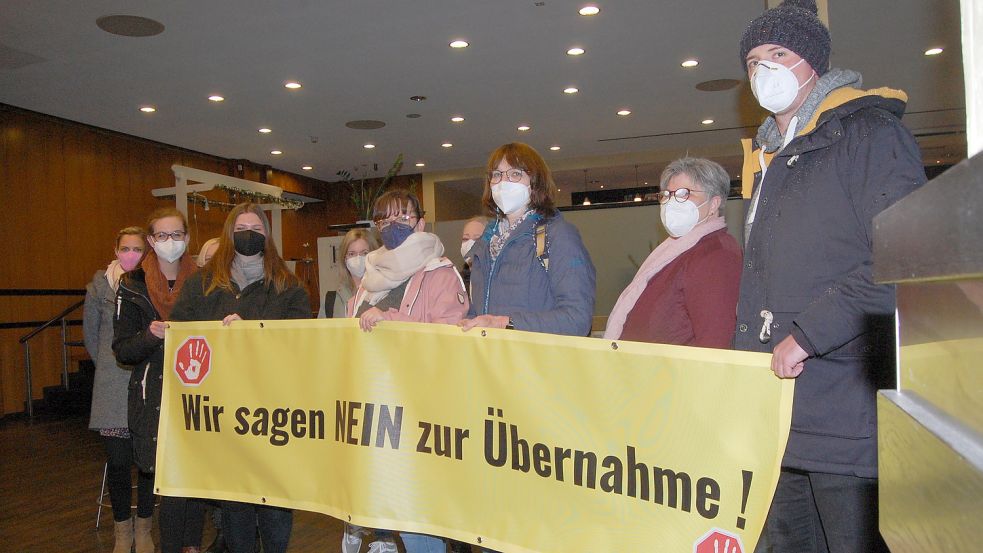 Im Foyer der Auricher Stadthalle protestieren Eltern und Kita-Beschäftigte gegen die geplante Übernahme der Kitas durch den Landkreis. Foto: Luppen