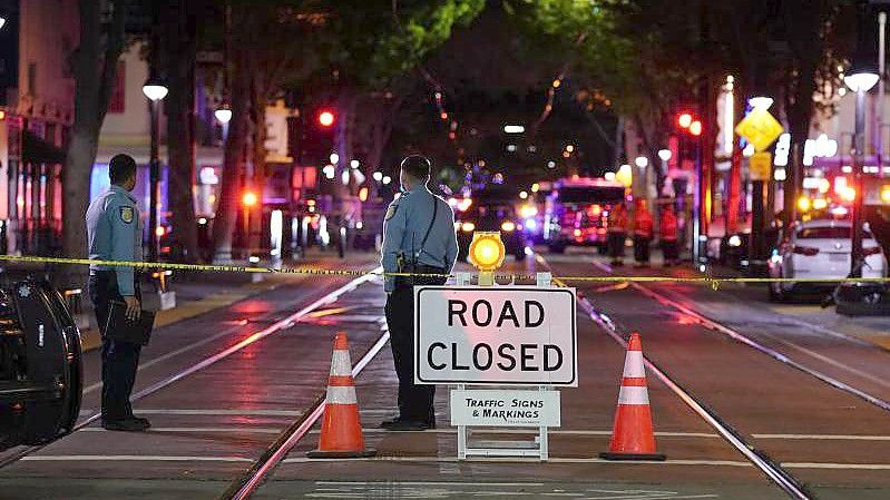 Zwei Polizisten stehen neben einer Straßensperre, die errichtet wurde, nachdem einen Block entfernt mehrere Menschen erschossen worden waren. Foto: Rich Pedroncelli/AP/dpa