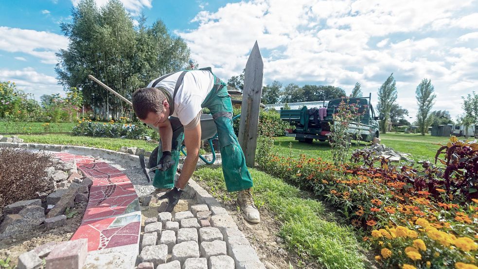 Wenn Wege im Garten gepflastert werden, sollte darauf geachtet werden, dass Regenwasser gut abfließen oder versickern kann. Foto: Reichdernatur/stock.adobe.com