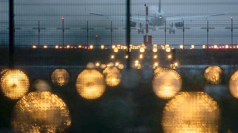 Ein Flugzeug landet hinter Signallichtern auf dem Flughafen Frankfurt. Die Flughafengesellschaft Fra. Foto: Sebastian Gollnow/dpa