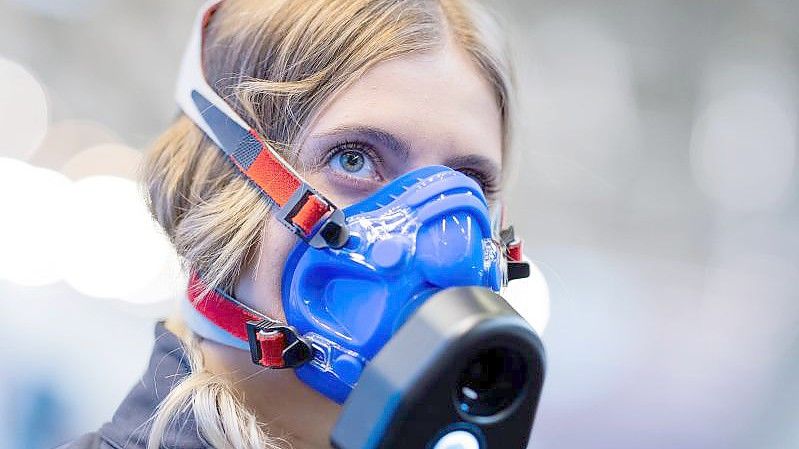 Eine Mitarbeiterin zeigt an einem Messestand auf der Fitnessmesse Fibo ein Messgerät für eine Atemanalyse. Foto: Rolf Vennenbernd/dpa