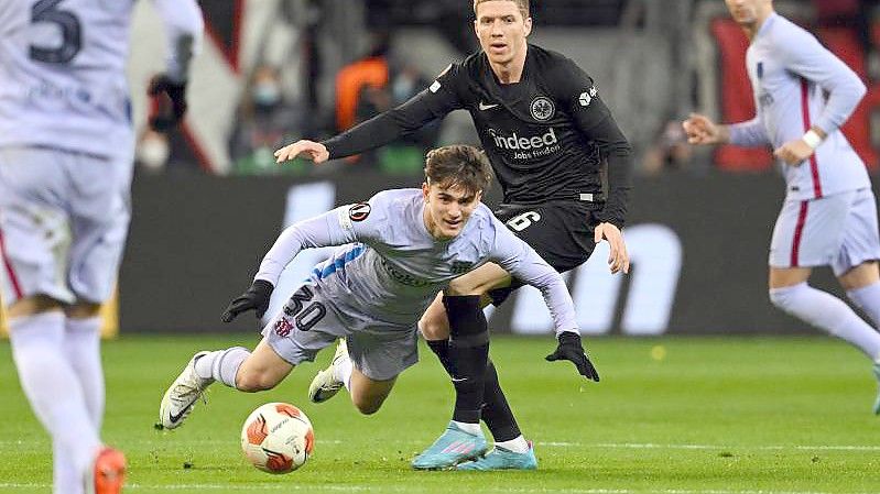 Frankfurts Kristijan Jakic (r) und Gavi vom FC Barcelona kämpfen um den Ball. Foto: Arne Dedert/dpa