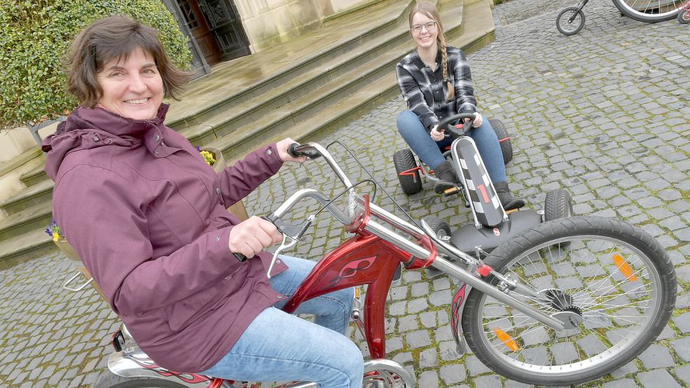 Leiterin der Evenburg Birgit Zimmermann auf einem Bonanza-Rad und Volontärin Dorothee Hoppe auf einem Kettcar. Foto: Ortgies