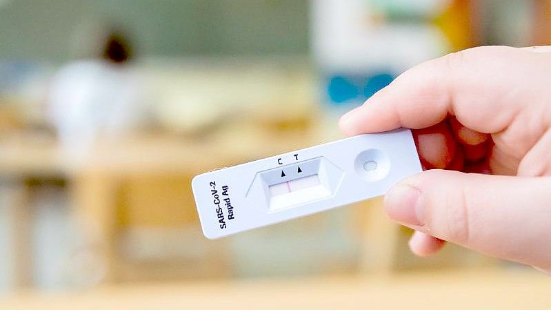 Ein Schüler hält bei einem Probelauf mit Corona-Schnelltests an der Grundschule in der Köllnischen Heide in Berlin-Neukölln seinen negativen Test in die Kamera. Foto: Christoph Soeder/dpa