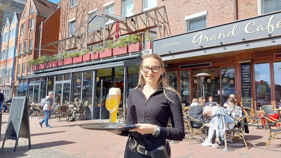 Das Grand Café am Stadtgarten war eine der Keimzellen der Außengastromie in der Emder Innenstadt. Für Servicekraft Anastasia Duzenko (Bild) gehören lange Wege zum Arbeitsalltag. Foto: M. Hanssen