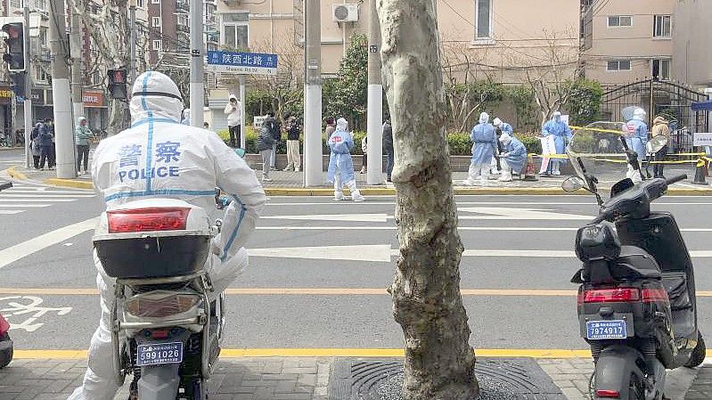 Ein Polizist in Schutzkleidung steht Wache im Jingan-Bezirk in Shanghai. Wegen der angespannten Corona-Lage ziehen die USA ihr Personal aus dem dortigen Konsulat ab. Foto: Chen Si/AP/dpa