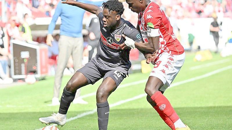 Der Stuttgarter Orel Mangala (l) schirmt den Ball gegen den Mainzer Moussa Niakhate ab. Foto: Torsten Silz/dpa