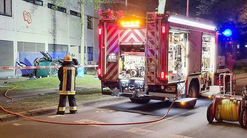 Ein Feuerwehrmann steht neben dem Wrack eines Autos, in dem zwei junge Männer aus der obersten Etage eines Parkhauses gestürzt und ums Leben gekommen sind. Foto: Markus Gayk/TNN/dpa