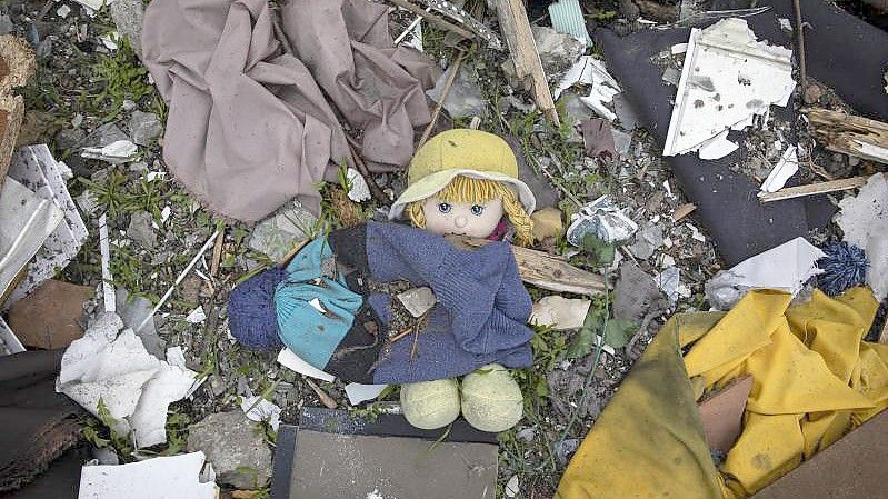 Eine Puppe liegt zwischen Trümmern. Foto: Alex Chan Tsz Yuk/SOPA Images via ZUMA Press Wire/dpa