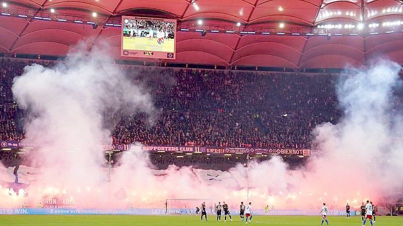 Fans vom HSV zünden Pyrotechnik auf der Tribüne. Foto: Marcus Brandt/dpa