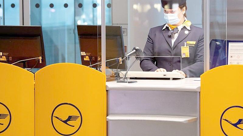 Eine Mitarbeiterin der Lufthansa bereitet am Flughafen München das Boarding für einen Flug vor. Foto: Sven Hoppe/dpa