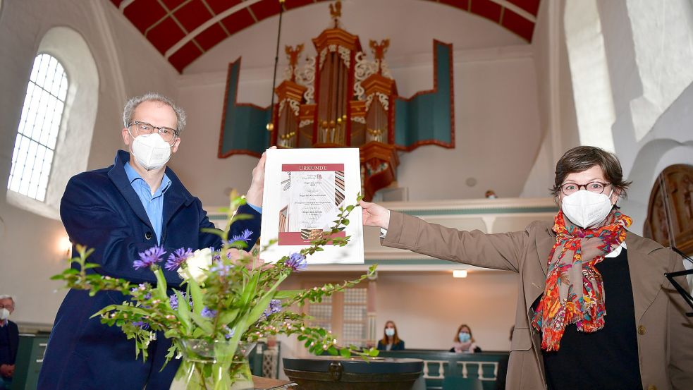 2021 wurde die Orgel in Uttum zur „Orgel des Jahres“ ausgezeichnet. Catharina Hasenclever, Geschäftsführerin der Stiftung Orgelklang, überreichte damals die Urkunde an Christian Janssen, Kirchenratsvorsitzender in Uttum. Foto: Wagenaar/Archiv