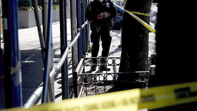 Ein Polizeibeamter steht in der Nähe des Tatorts, an dem eine junge Frau bei einer Schießerei in einem Wohnhaus in Brooklyn getötet wurde. Foto: Seth Wenig/AP/dpa