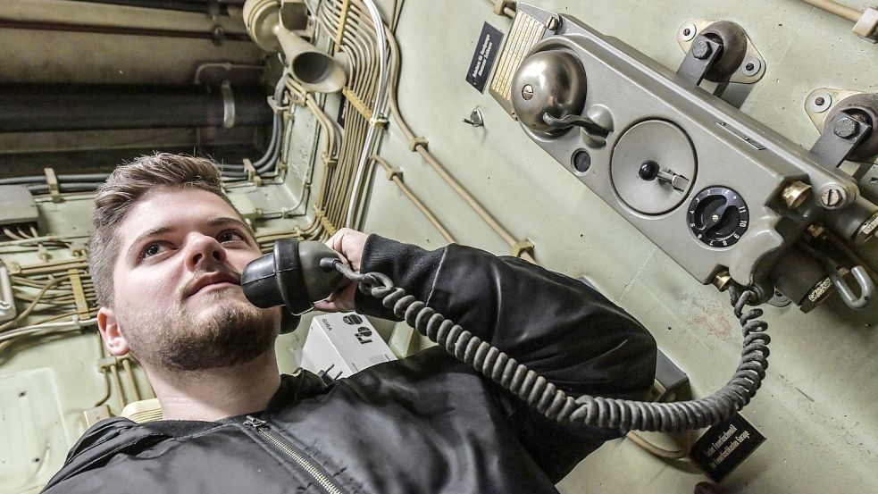 Manuel Rösecke, Verwaltungsfachwirts-Auszubildender bei der Stadt Norden, greift zum Hörer. Alte Telefone wie dieses verbinden die Bunkerräume miteinander. Fotos: Ortgies