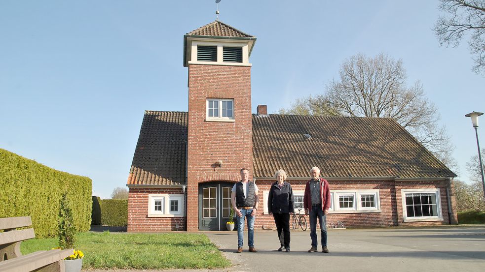 Von links: Marco Beyen (Ortsrat), Linda Hagedorn (Dorfgemeinschaft) und Ortsbürgermeister Eilert Caspers vor dem Dorfgemeinschaftshaus Fiebing