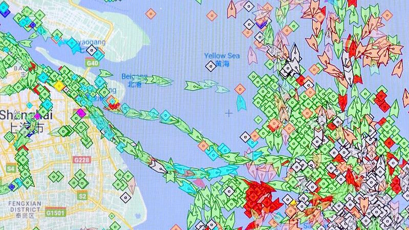 Auf einem Smartphone-Monitor ist die App „MarineTraffic“ zu sehen, die die Positionen von Frachtschiffen (grün) vor dem Hafen von Shanghai anzeigt. Foto: Erich Braunsperger/dpa