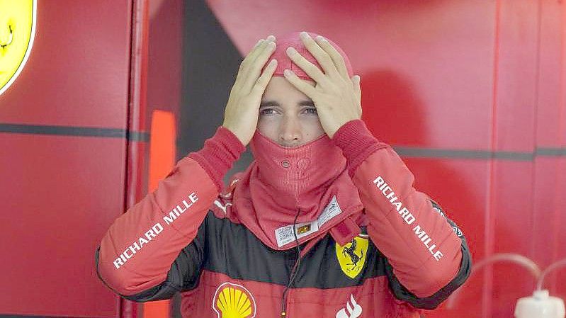 Ferrari-Pilot Charles Leclerc setzt vor Beginn des Freien Trainings seine Sturmhaube auf. Foto: Luca Bruno/AP/dpa
